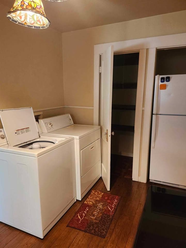 A laundry room featuring a washing machine, dryer, and a door leading to a pantry.