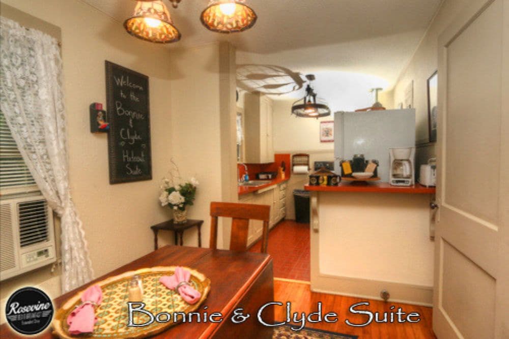 Cozy kitchen area of the Bonnie & Clyde Suite featuring a dining table, cabinets, and welcoming decor.