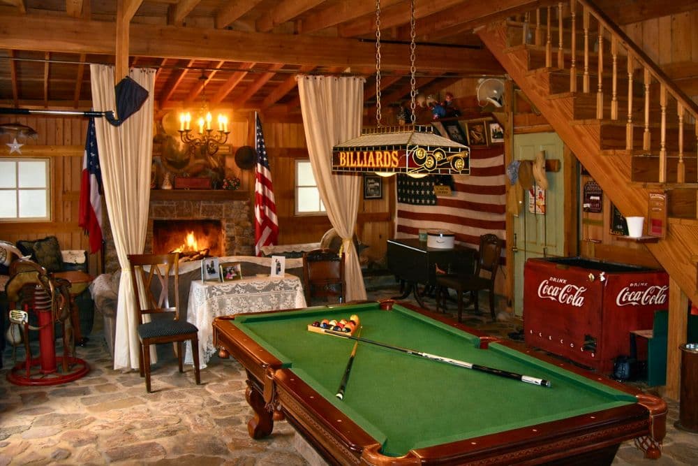 Cozy game room featuring a billiards table, fireplace, and American decor.