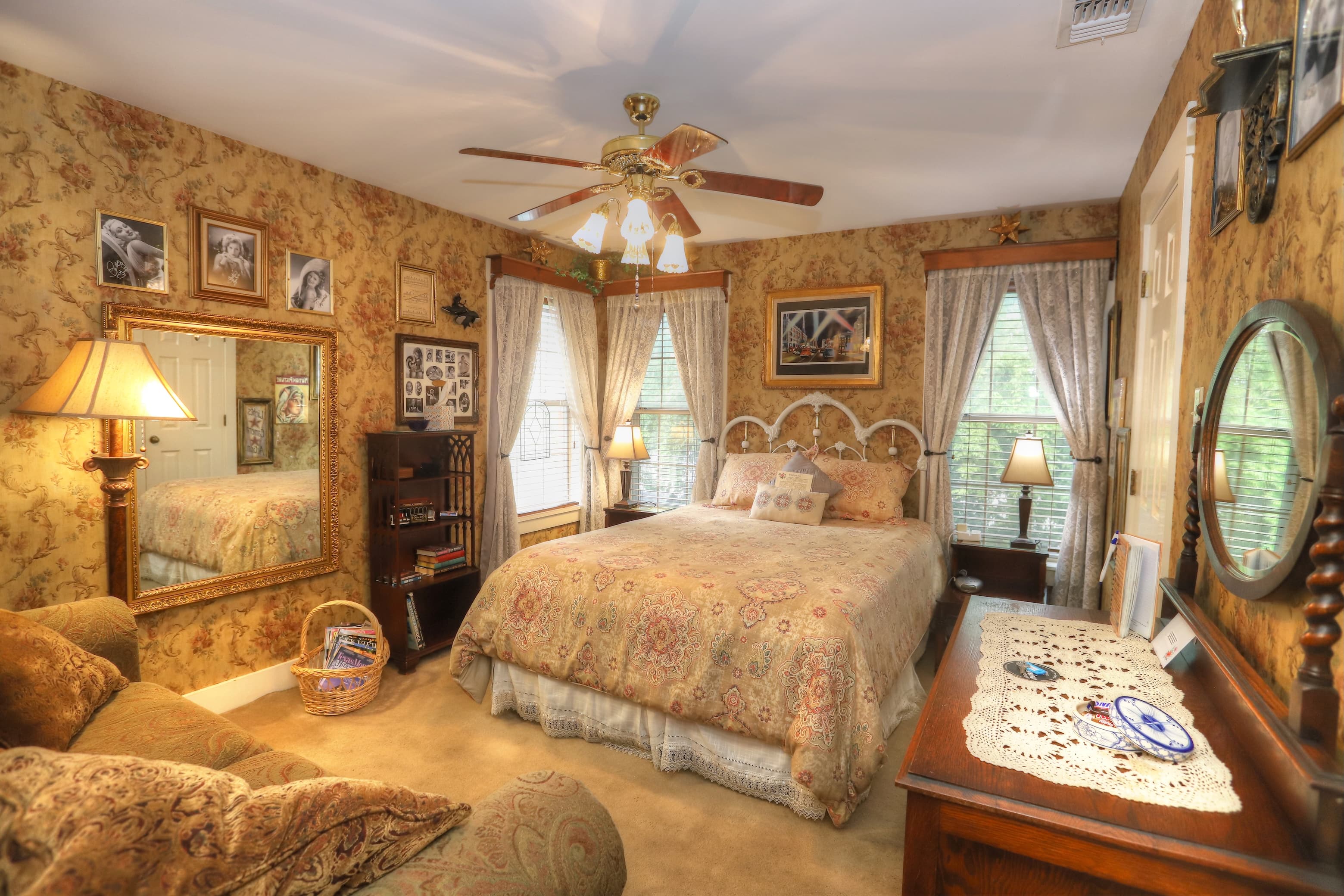 An upstairs bed and breakfast bathroom with creme walls and brown wainscotting. There is a walk in shower, sink and commode.