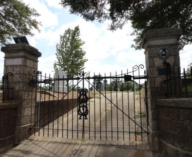 iron double gate between two stone columns driveway entrance to Oakwood cemetary
