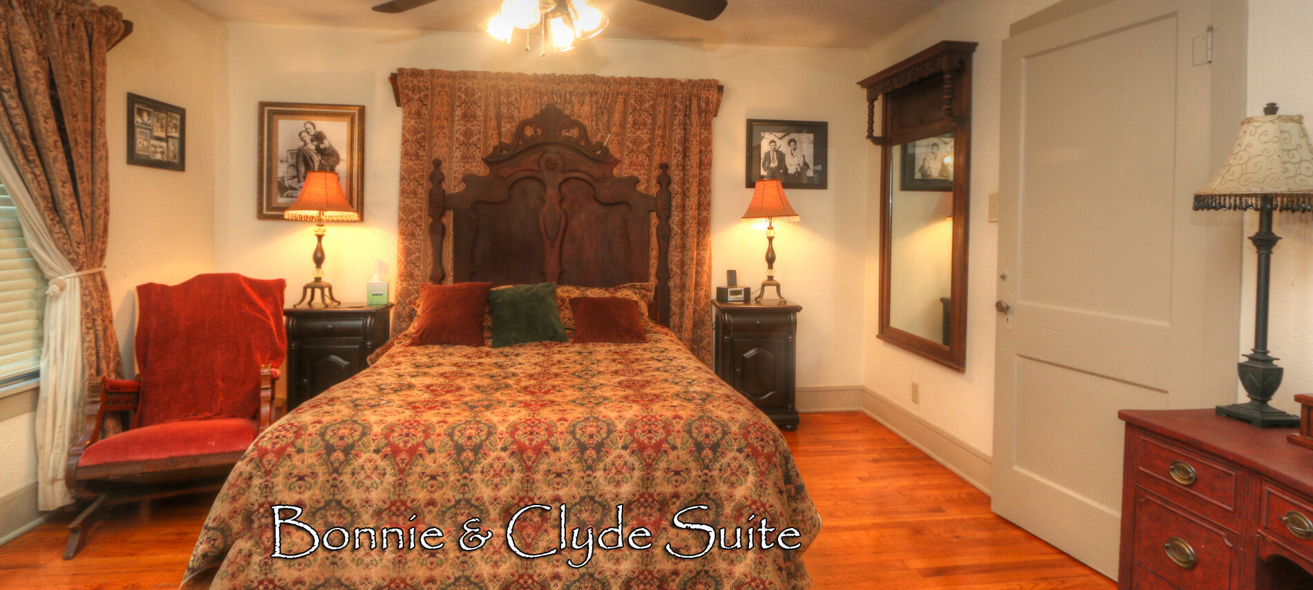 Bedroom featuring ornate high back bed with golden tapestry spread with a view through the open door of a coordinating living room