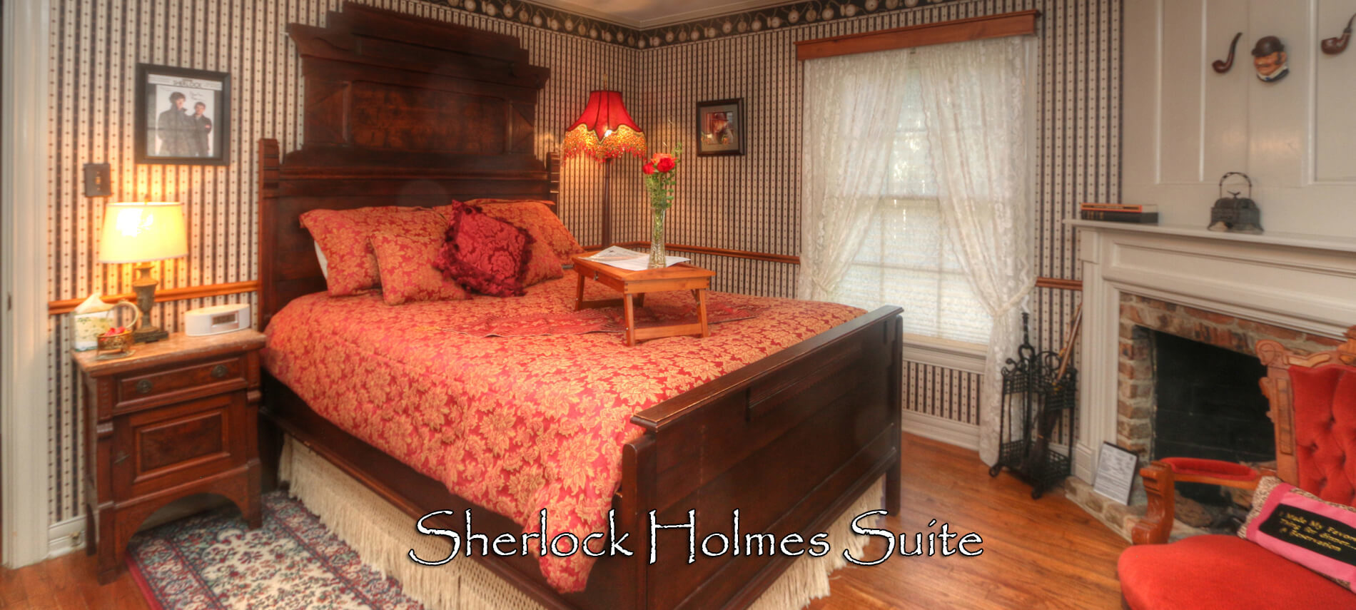 Sherlock Suite with high-back wooden bed covered in red comforter with lap tray and flowers