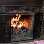 outdoor fireplace roaring with a cozy fire