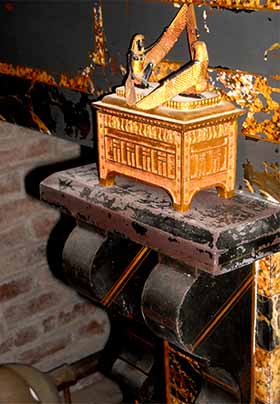 Close up of black and gold marble fireplace with ark of the covenant statuette