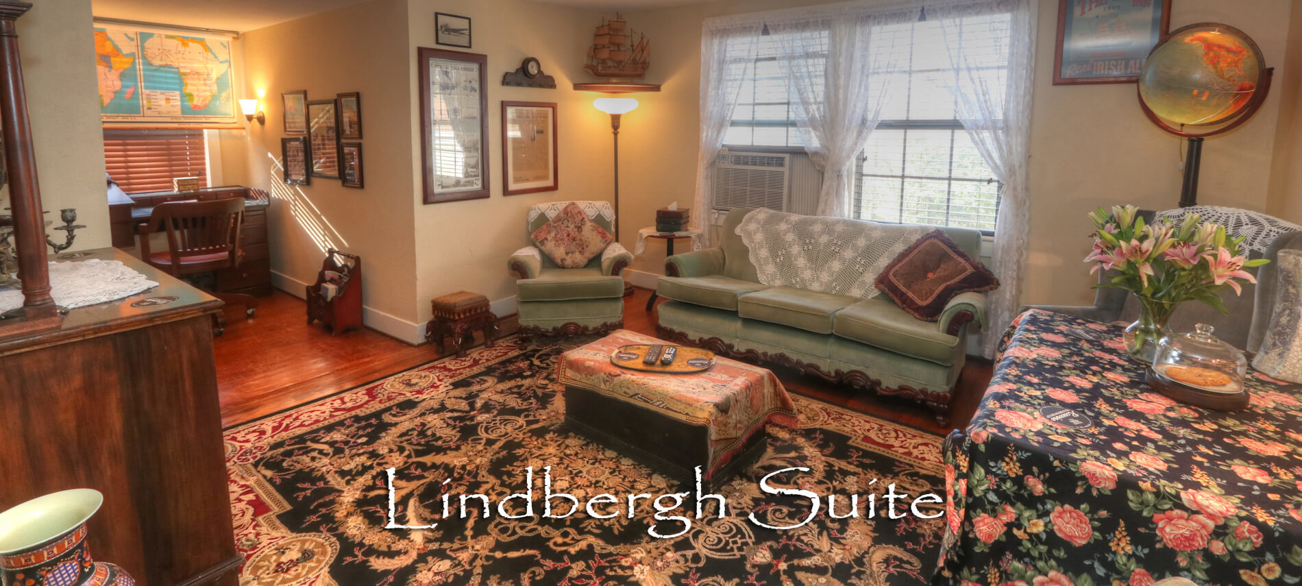 Vintage Living Room in the Lindbergh Suite with Green couches and antique wall hangings