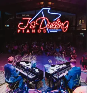 2 men in blue suits playing pianos with the words Js Dueling pianos in Red and Blue Neon