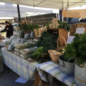 table with blue and white stripes filled with produce for sale