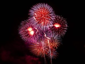 red and purple fireworks display on a black background