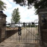 iron double gate between two stone columns driveway entrance to Oakwood cemetary