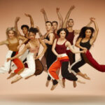 8 men and women dancers all jumping in the air