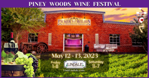 picture of The Pickers Pavillion in Lindale-it is a red style barn building with wording at the bottom that says May 12-13 Friday 1-8 and Saturday 11-7 word at the top are white on purple background that says Piney Woods Wine Festival