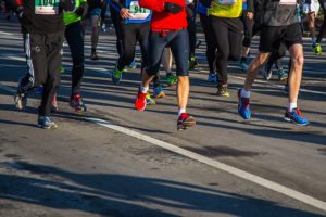 Feet running in a race, white line in the middle of photo