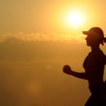 person with a cap on Running with a sunset in the background