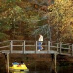 Brodge over water at Tyler State Park Man walking on it and Yellow Paddleboat under it