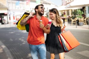 man and women holing shopping bags and smiling