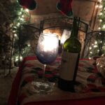 wine glass with white lights on both sides and a fireplace in the background