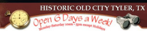 Rectangular sign maroon on top with words in white says HISTORIC OLD CITY TYLER, TX on the bottom, which is white, are the words in red OPEN 6 DAYS A WEEK MON-SAT. there is a antique pocket watch on the left and a depictions of antique binoculars